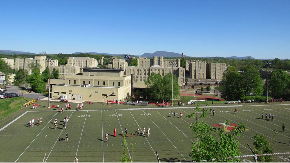 Football players gathering on Alumni Memorial Field.