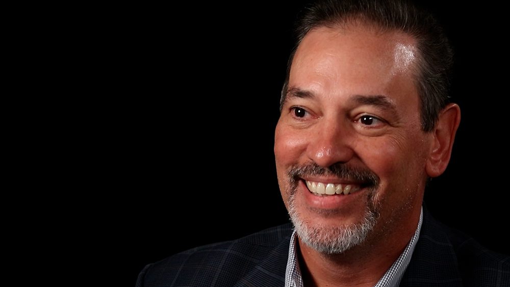 Pablo Martinez '90 smiling against a black background.