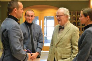 Floyd Gottwald Jr. ’43 smiling and talking with three cadets.