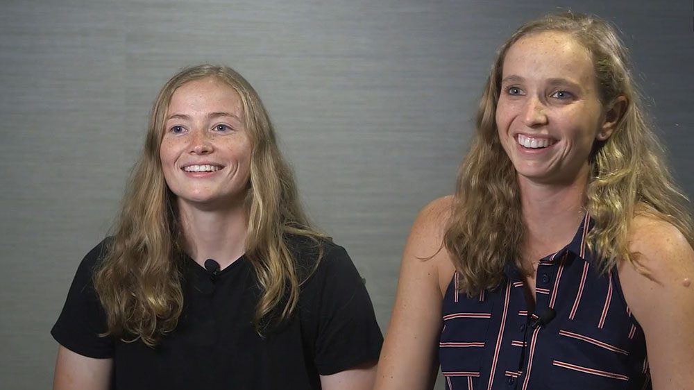 Sisters Maddie and Catie Berry sit side-by-side, smiling.