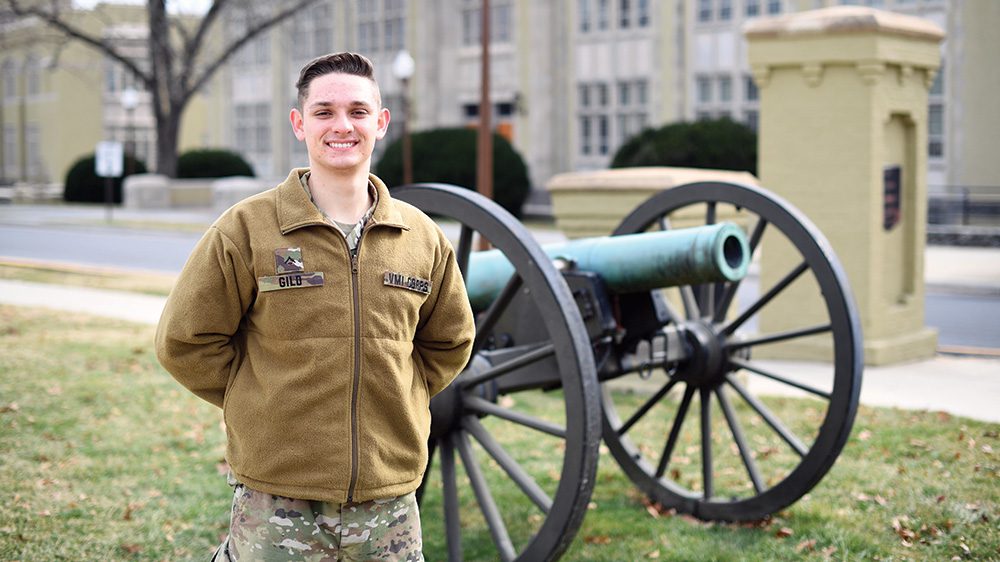 Cadet Adam Gild posing in front of cannon.