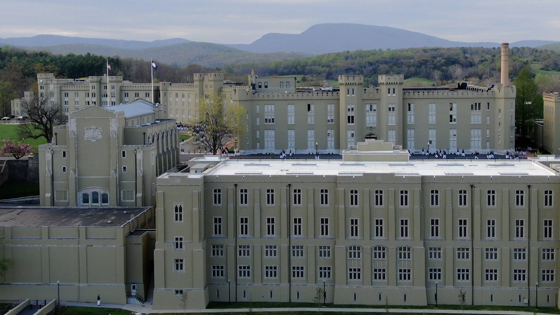 aerial shot of the side of barracks with mountains in background