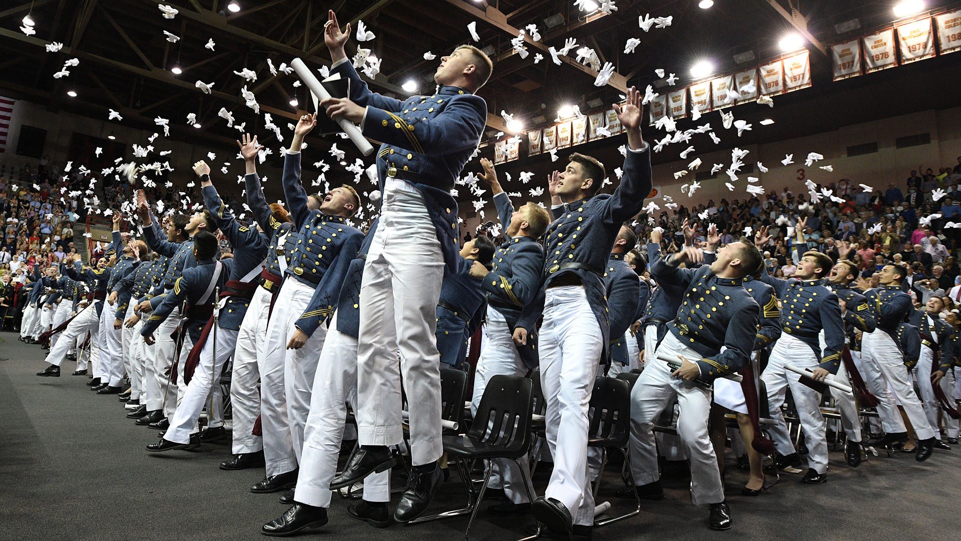 cadets throwing gloves in the air at graduation in Cameron Hall