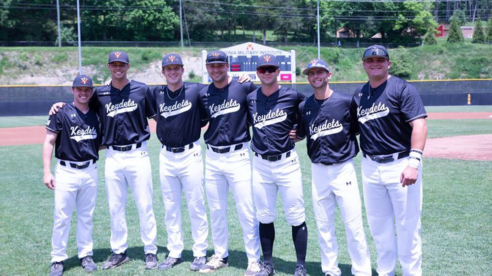 Seven senior baseball team members stand with arms around each other, smiling.