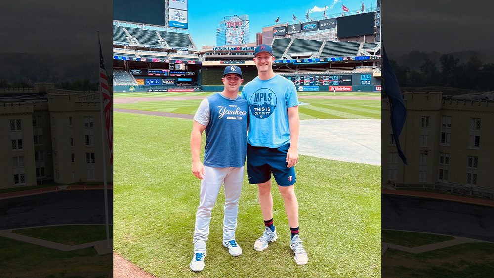 Josh Winder '19 poses for a photo with Casey Dykes on baseball field.