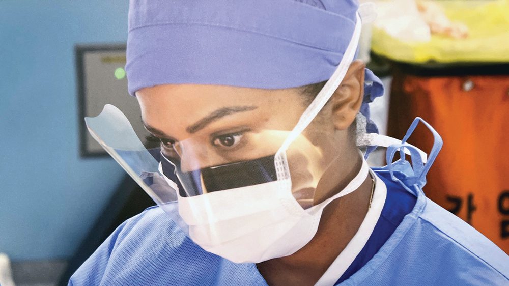 doctor with scrubs, face mask, and face shield