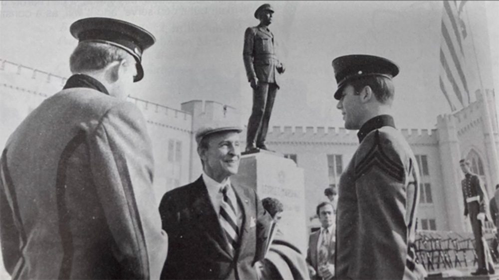 Frank McCarthy and two others conversing in front of Marshall statue.