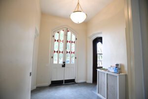 interior of Superintendent's Quarters; light fixture hanging from ceiling and doors with stained glass windows