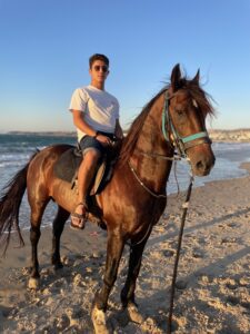 Antonio Ahanj ’24 rides a horse on the beach of Tangier, Morocco.