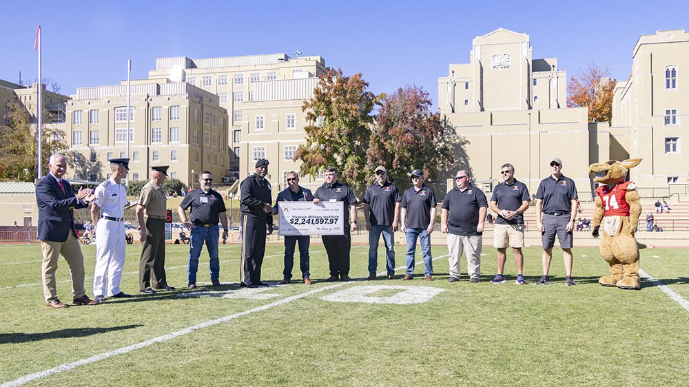 Class of 1997 presenting check to Institute on football field