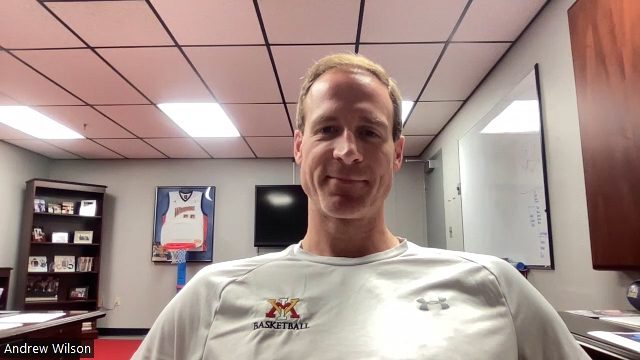 Basketball coach Andrew Wilson sitting in his office