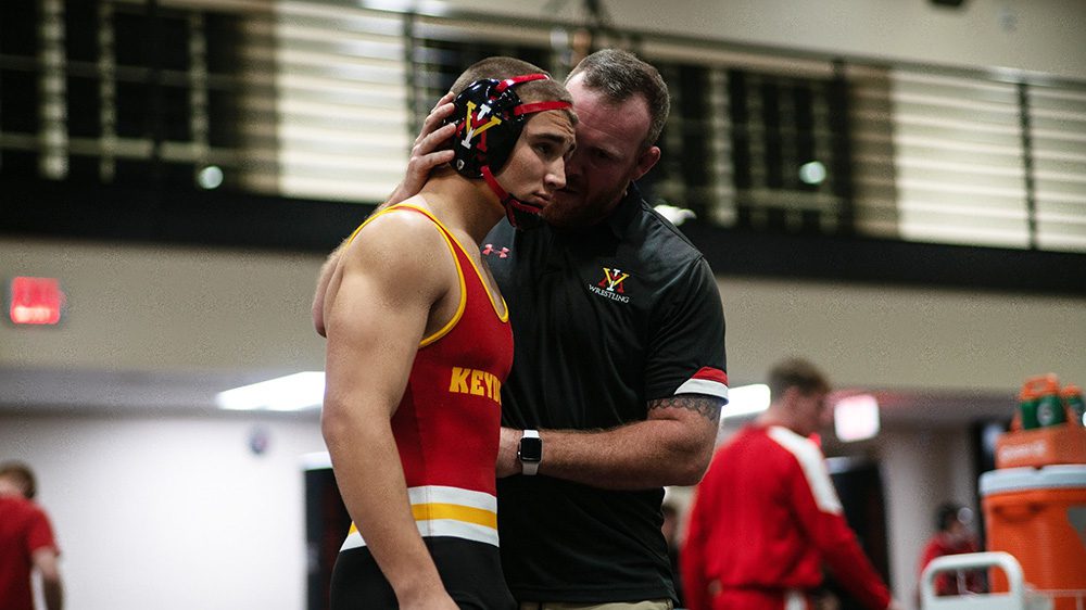 wrestling coach talking to wrestler