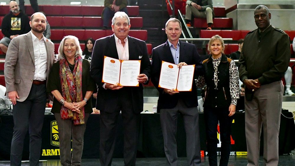 Coach Ike Sherlock and Jesse Waltz '85 pose with others as they celebrate the establishment of their wrestling scholarship.