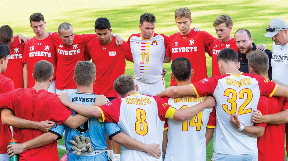 soccer players in huddle