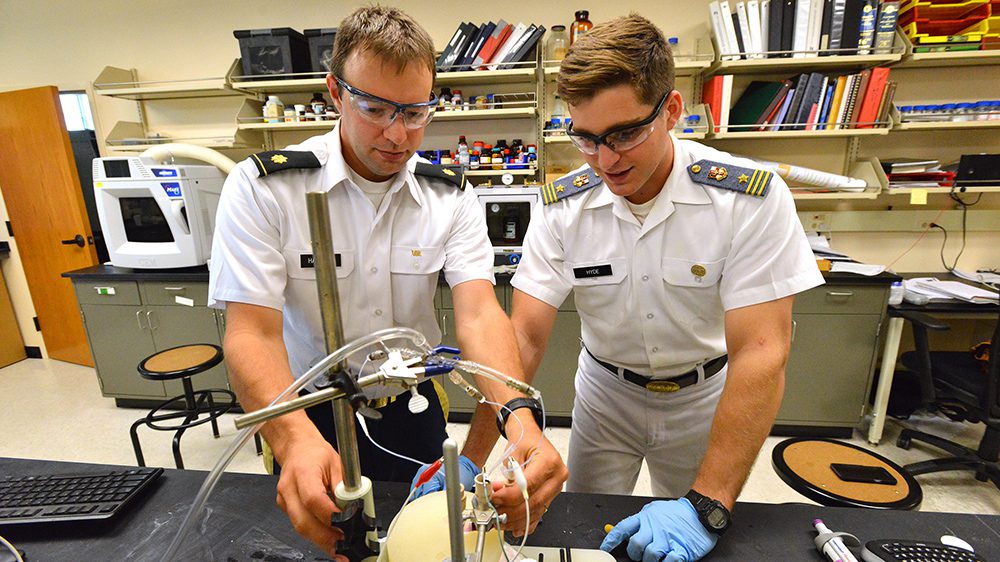 Lieutenant Colonel Daniel P. Harrison ’05 assisting a cadet in a lab.