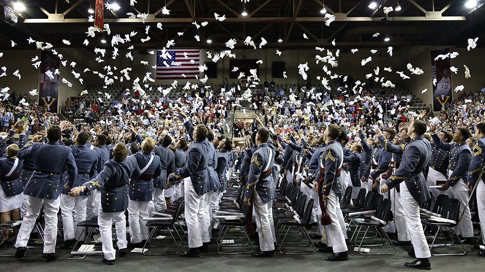 graduating cadets throwing gloves in the air