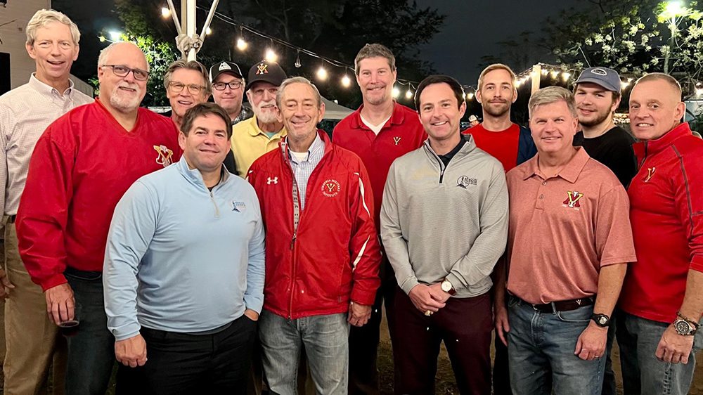 alumni smiling at a nighttime event