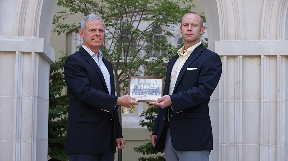 Steve Walker ’71 and Stephen M. Walker II ’04 hold a photo of the 1927–28 rat basketball team.