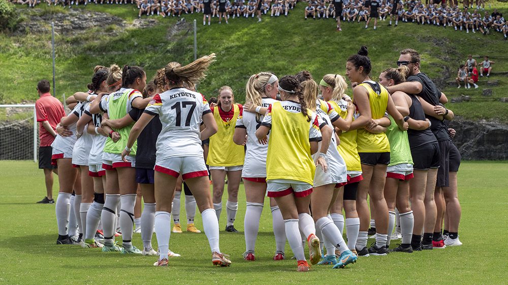 women's soccer team gathered in a huddle