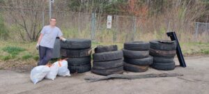 Johnny Partin '14 posing with tires, at a river clean-up event in Hopewell, Virginia.