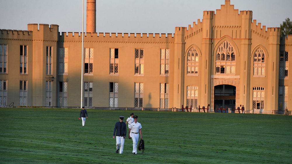 cadets walking on the VMI parade ground, old barracks in the background