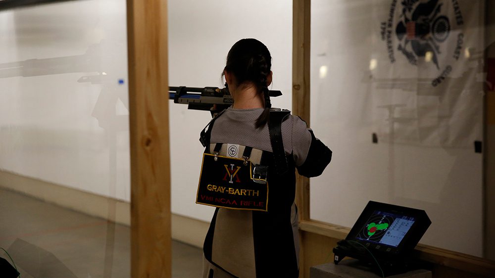 rifle team member aiming rifle at target