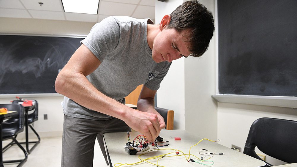 Brian Tavenner ’25 works on the electrical components of the rocket.