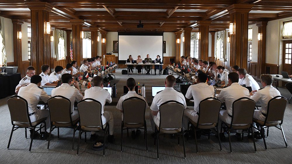 group of cadets sit around conference tables in model NATO convention