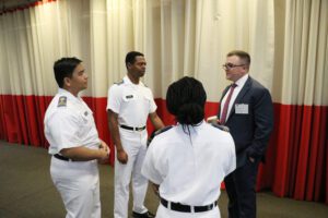 alumnus conversing with group of three cadets