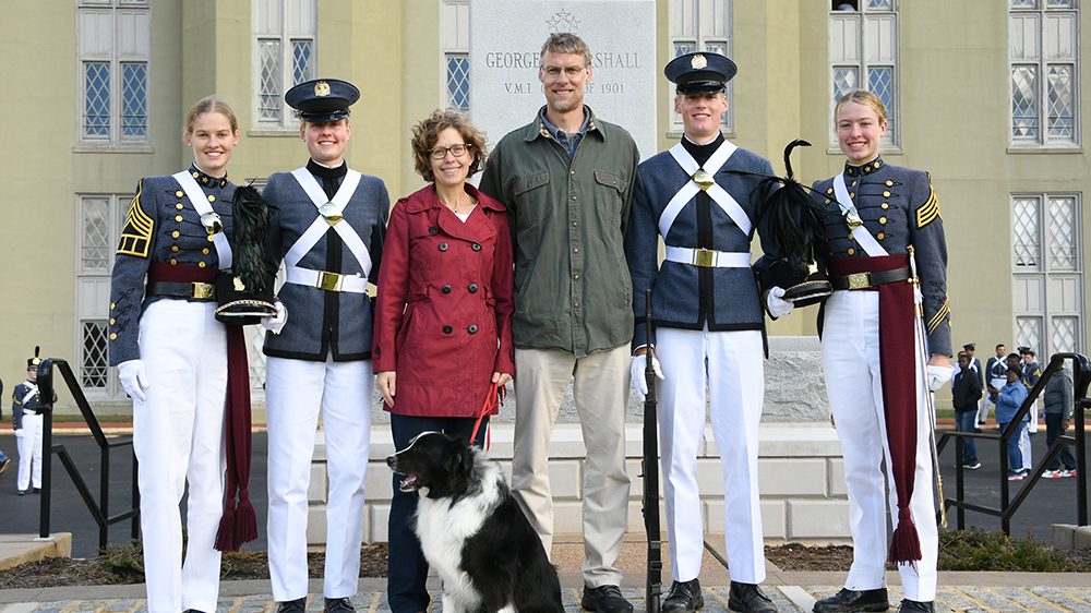 Cadets and their parents and family dog pose in front of Gen. George C. Marshall statue.