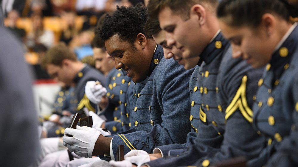 cadets looking at class rings, smiling