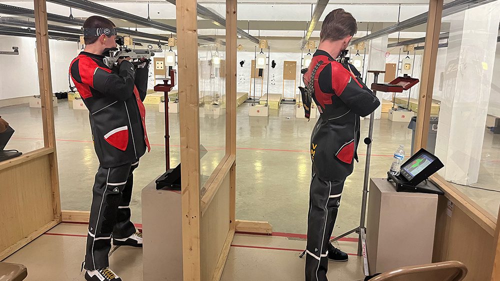 Rifle athletes aiming at target