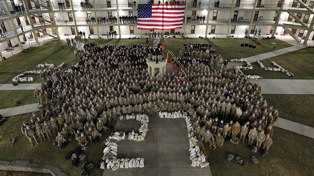 Class of 2027 posing with sandbags in the shape of 