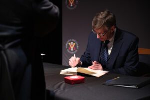 Robert Child signs a copy of his book