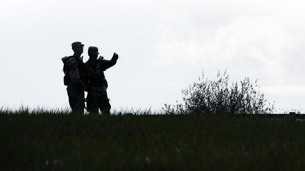 silhouette of two soldiers in a field