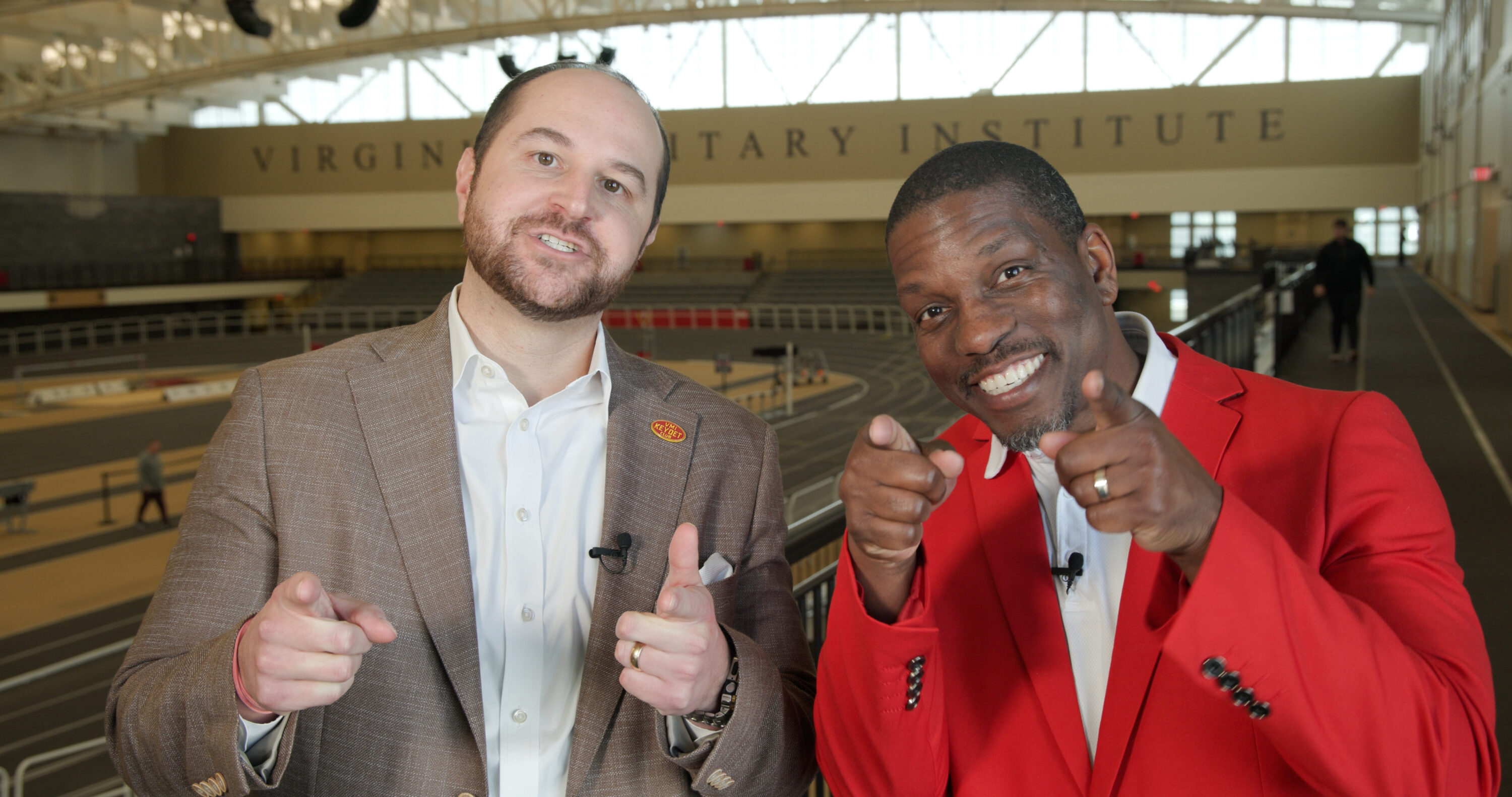 Two people smiling and pointing at the camera