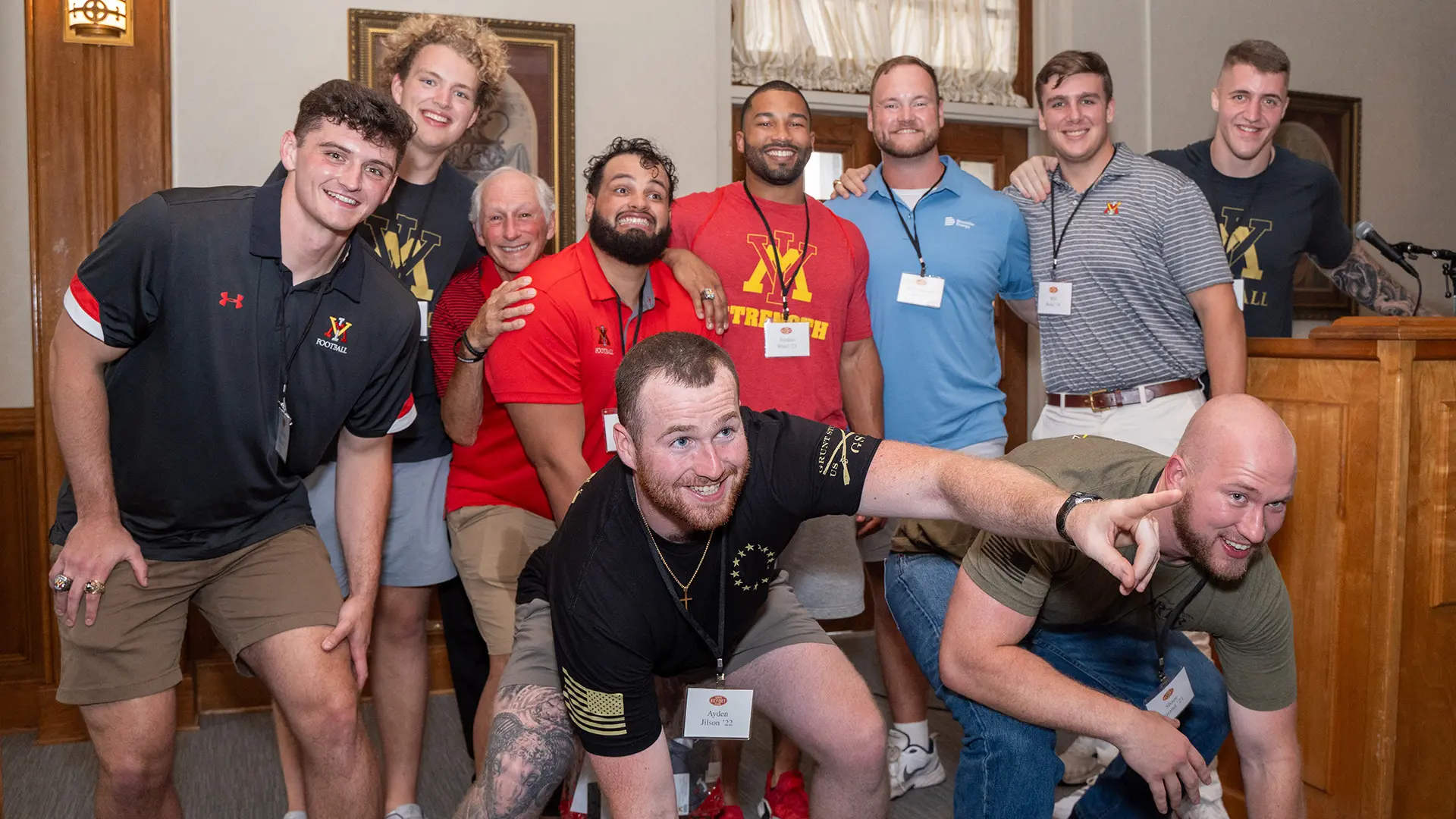 Alumni smiling at football reunion in Moody Hall