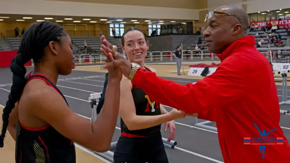 track coach high-fiving athlete