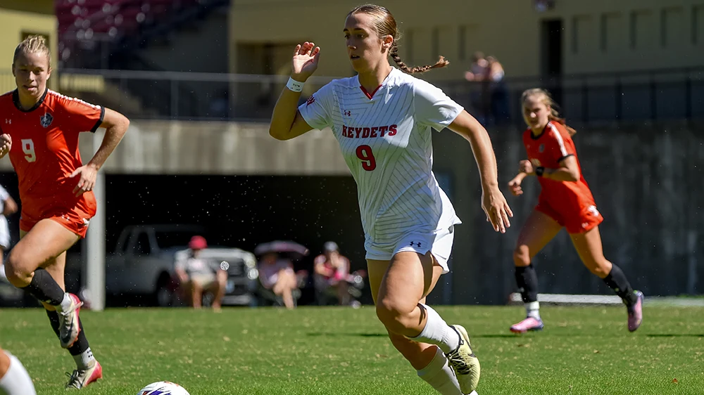 female soccer player running after ball