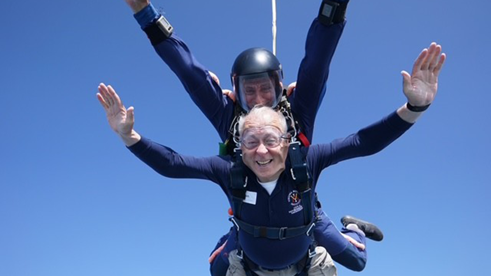 man and instructor sky diving, smiling
