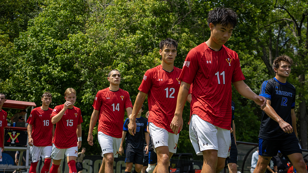 male soccer players in red jerseys walking